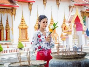 a buddhist woman tending to the outside of a sacred space